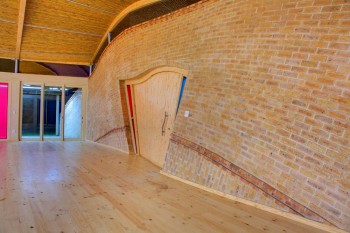 The attractive building has undulating brick lines and meandering surfaces