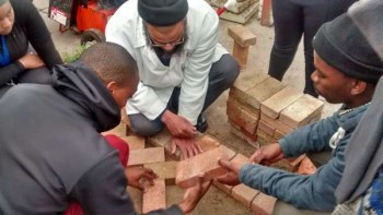 Cape Peninsular University of Technology students pave the courtyard at the Matthew Goniwe 2 residence on the Bellville campus during the Corobrik-CPUT Construction Week.